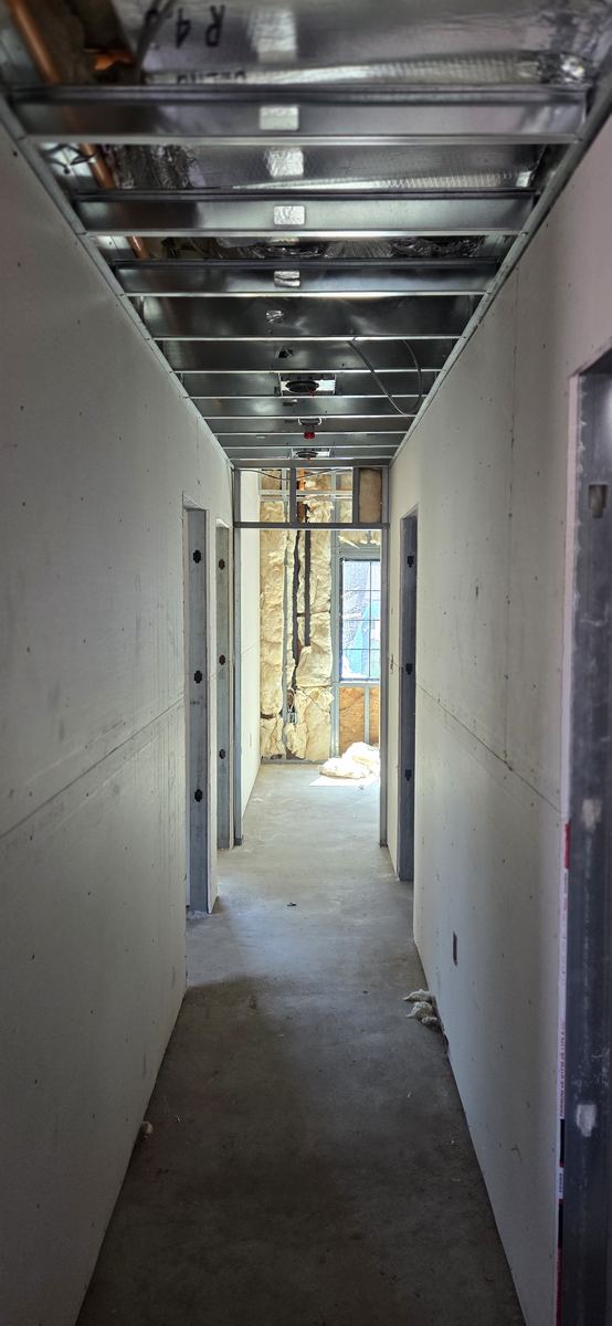 Corridor boarded and finished, running the length of the floor.