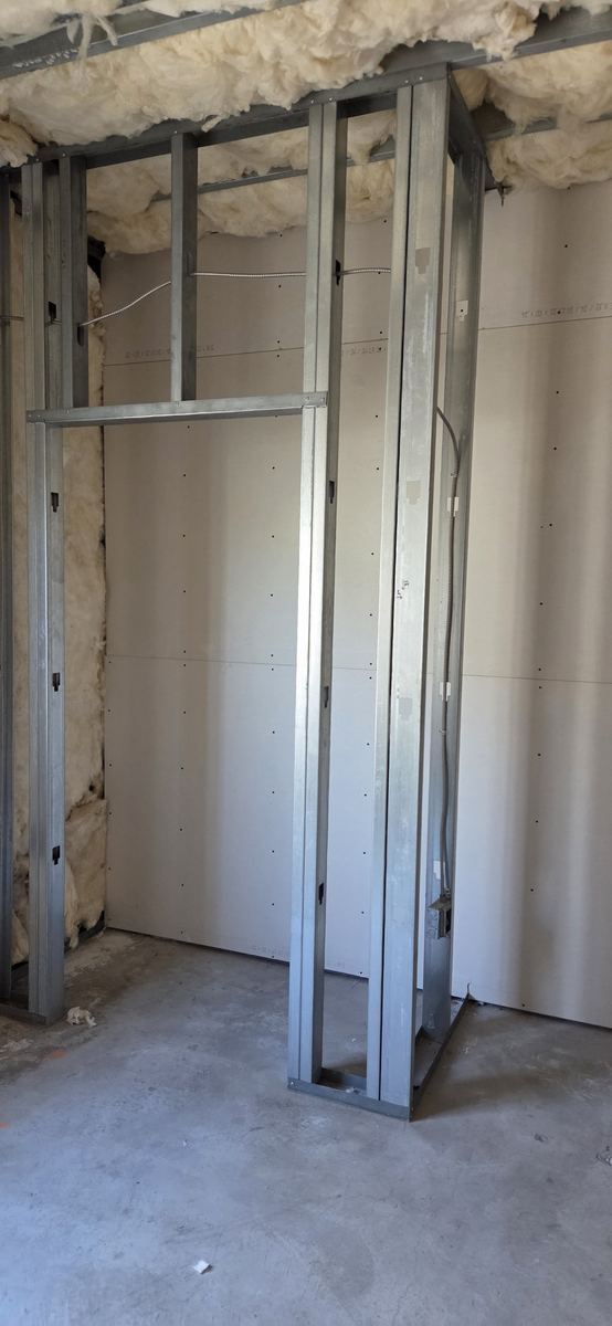 Steel stud partitions stood and braced, ready for services.